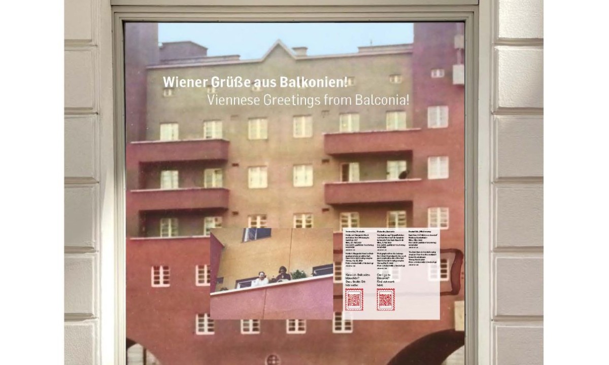 Schaufenster mit Ausstellung 'Wiener Grüße aus Balkonien!' im Jüdischen Museum Wien, zeigt Foto von Balkon mit Menschen und Text in Deutsch und Englisch