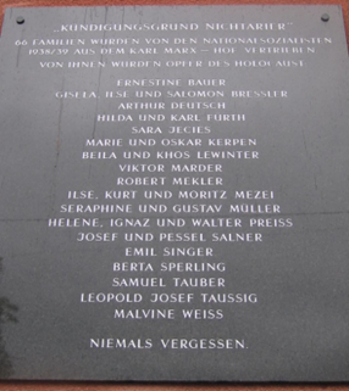 : Gedenktafel mit Namen von Opfern des Holocaust, darunter Ernestine Bauer, Sara Jices, Viktor Marder, und der Satz 'Niemals vergessen'