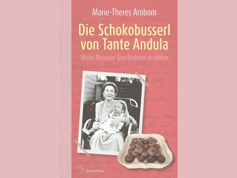 Buchcover mit Titel 'Die Schokobusserl von Tante Andula' von Marie-Theres Arnbom, darunter ein Schwarz-weiß-Foto einer Frau mit Kind und ein Bild von Schokoladenplätzchen.