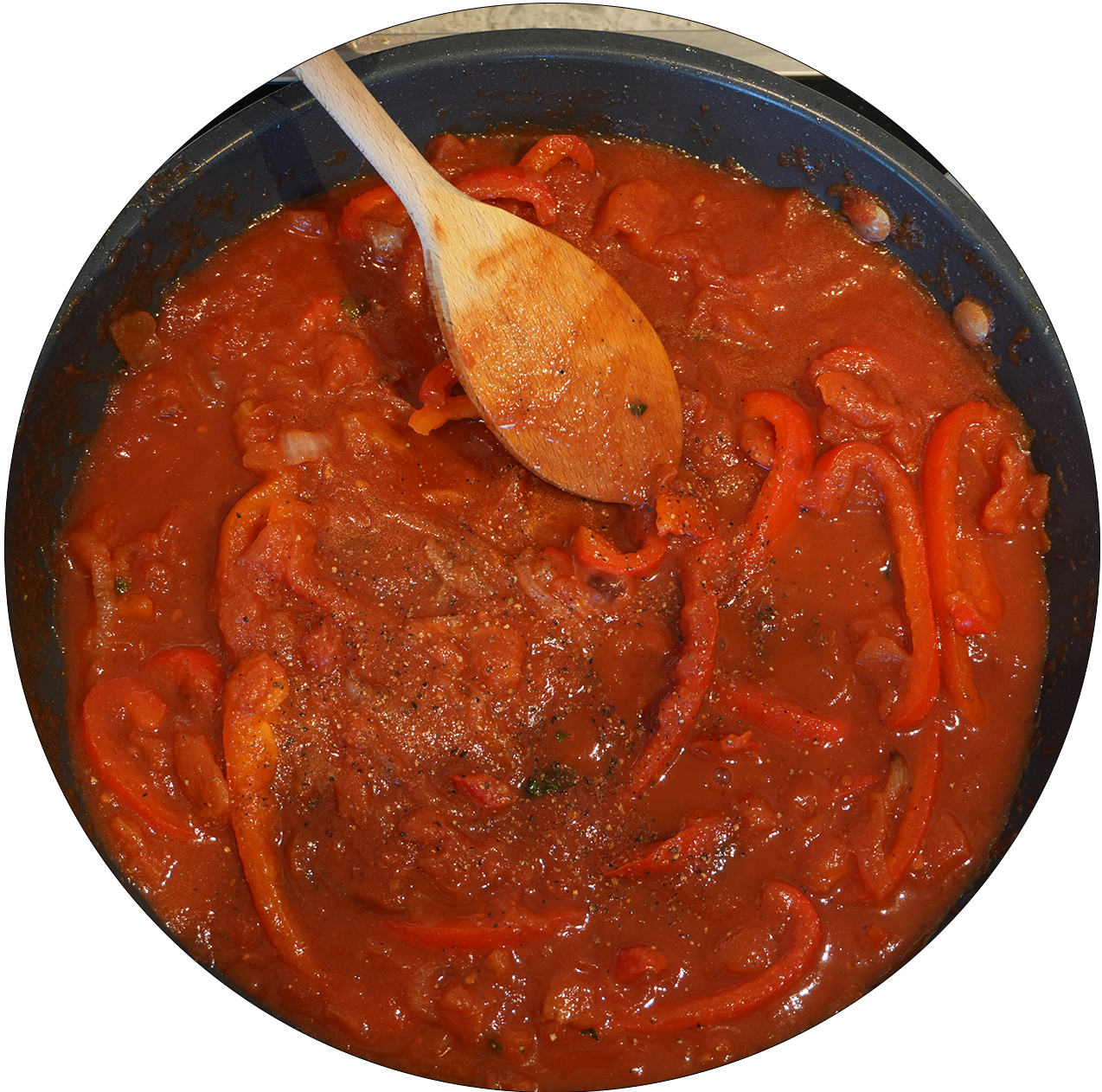 Pfanne mit roter Tomatensauce und roten Paprikastreifen, Holzlöffel darin.