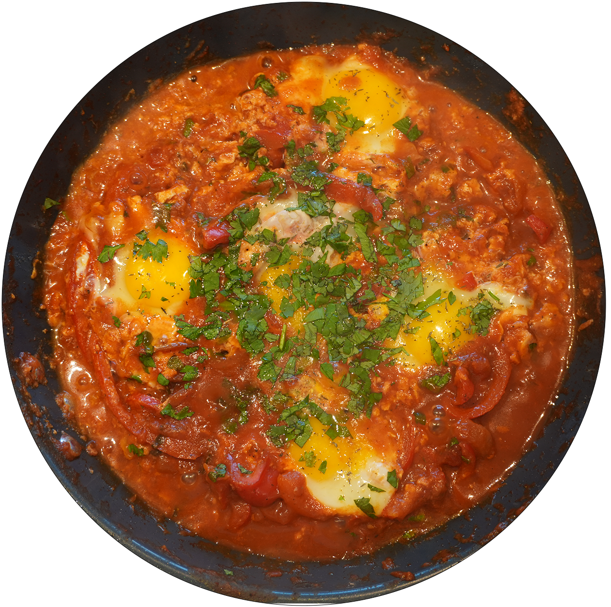 Pfanne mit vier Spiegeleiern in Tomatensauce, garniert mit gehackter Petersilie.