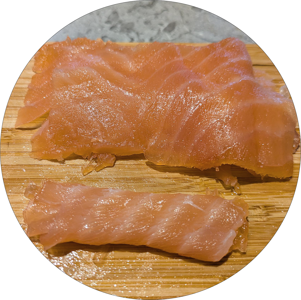 Zwei Stücke graved Lachs auf einem Holzbrett